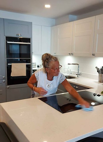 Cleaning lady polishing kitchen